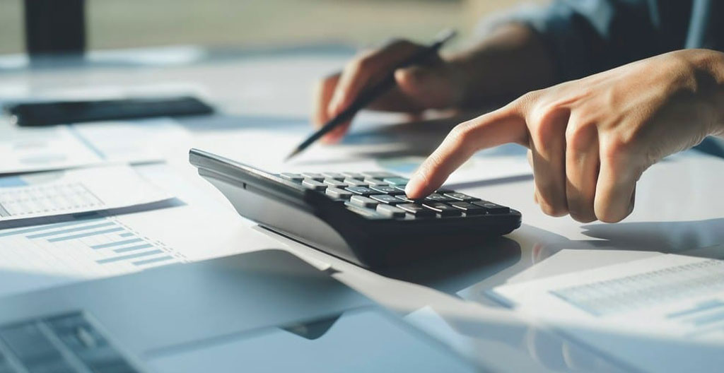 Gros plan sur une feuille de calcul montrant l'évolution comparée de deux placements sur 15 ans, posée sur une table de travail claire, avec un crayon posé à côté